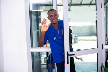 portrait of a doctor opening the clinic door, smiling