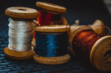 Retro sewing items: tailoring scissors, cutting knife, thimble, wooden thread spools, cushion for...