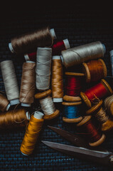 Retro sewing items: tailoring scissors, cutting knife, thimble, wooden thread spools, cushion for...