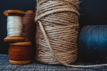 retro sewing tools: old scissors, bobbins of thread on gray fabric. Tailor's desk. manufacture of...