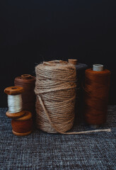 retro sewing tools: old scissors, bobbins of thread on gray fabric. Tailor's desk. manufacture of textiles or fine fabrics.