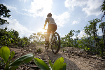 Fototapeta na wymiar Woman cycling on mountain top forest trail, slow motion