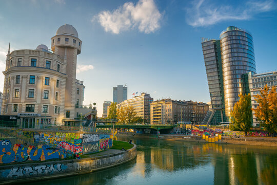 vienna, austria - OCT 17, 2019: architecture on donaukanal at sunset. water way betweein famous buildings of urania observatory and uniqa tower in evening light. popular travel destination in autumn