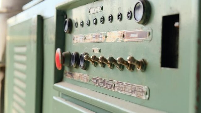 old electrical panel in abandoned factory with red button and shiny position switches. Machine control panel. Inscriptions in Russian FIBER OUTPUT, INNINGS, DRUMS, FLAP CONTROL, ADJUSTMENT