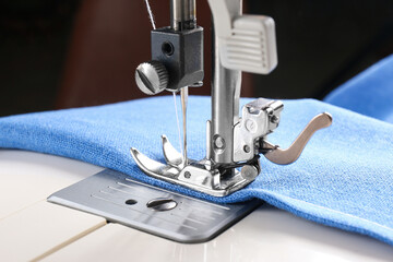 Sewing machine with light blue cloth, closeup