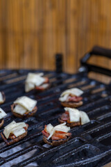 grilled mushrooms with bacon and cheese on a garden grill