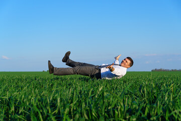businessman simulates flight in a green field, business and freedom concept, green grass and blue...