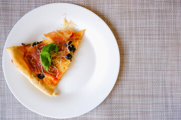 Appetizing delicious pizza. Close-up top view of slices of pizza on a white plate. Place for text.