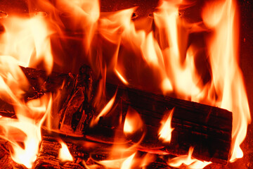 Firewood is burning in the fireplace. Close-up view of the fire. Background.