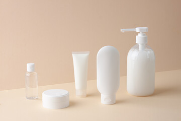 Cosmetic composition with skin care products on pastel beige background. Close up.