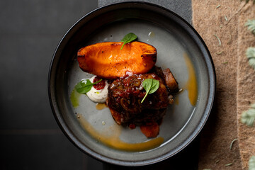Waiter is holding a gourmet steak in a christmas decorated restaurant