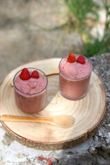 Banana and berry nice cream, served in a garden. Selective focus.