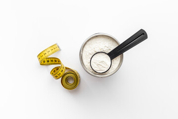 Whey protein in scoop and jar with tape measure. Sport nutrition