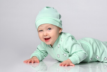 charming boy in a sprawling and sliders and a hat. Newborn baby is resting. Baby Todler joyfully...