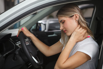 Young woman suffering from neck whiplash, sitting in drivers seat of her car - obrazy, fototapety, plakaty