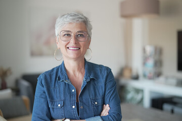 Fototapeta na wymiar portrait of a 55 year old smiling senior woman in her home