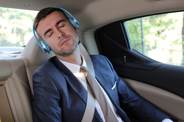 Man sleeping with headphones on business travel