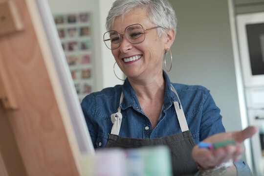 portrait of a 55 year old senior woman doing art painting