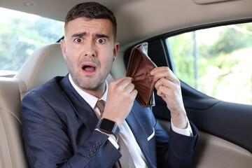 Surprised businessman with empty wallet after paying taxi - obrazy, fototapety, plakaty