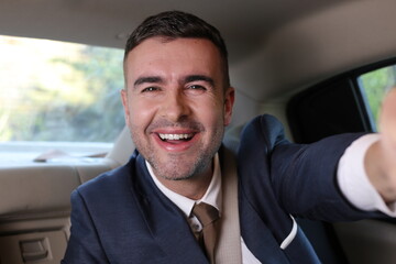 Gorgeous man taking selfie during business travel