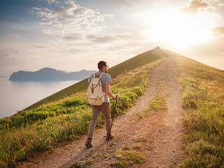 Young man travels alone on the backdrop of the mountains