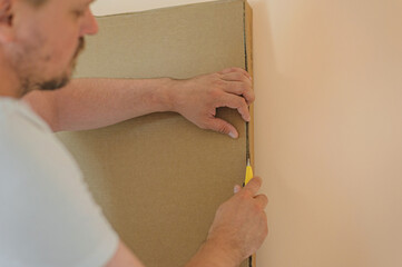 a man cuts a box of furniture with a stationery knife. close-up