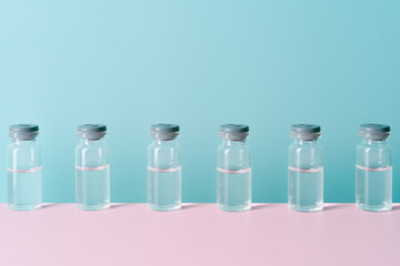 vials with liquid on pink and blue background. Concept of medicine and coronavirus. copy space