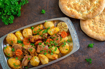 Roast pieces of turkey with vegetables serving on the metal tray with fresh tortillas. Top view, flat lay.