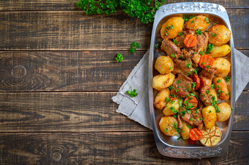 Roast pieces of turkey with vegetables serving on the metal tray on wooden background. Top view, flat lay. Copy space