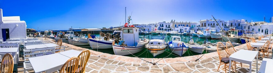 Greece travel. Cyclades, Paros island. Charming fishing village Naoussa. view of old port with  boats and restaurants (taverns) by the sea. may 2021