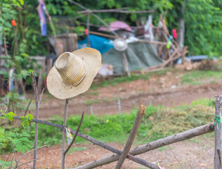 Farmer's Hat hanging on a wooden fence