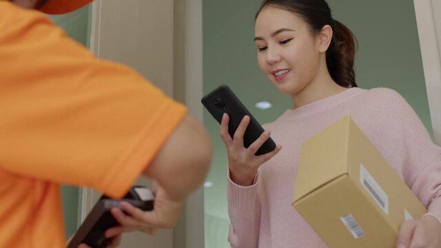 Asia young smile happy woman people receive parcel postal from e-commerce online shop store use tapping cashless wifi qr code nfc bill scan app smart pos device reader in city life home contactless.