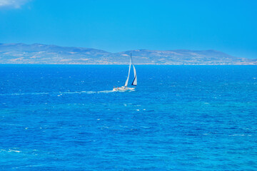 Greece famous Paros island in cyclades,view of paros island with a sail boat in foreground