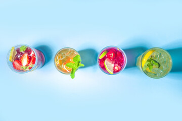 Iced refreshing drink. Bar and caffee beverage menu background. Set of various cold summer cocktails - peach tea, lemonade, mojito, cherry mocktail, with frruits on colorful bright blue background