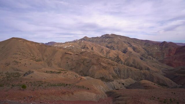 Panoramic view of high Atlas Mountain range with scenic sky in Morocco - panning shot