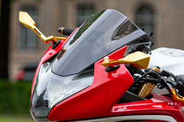 closeup of the headlights of a red sports motorcycle on the street