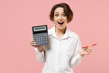 Young smiling successful employee business secretary woman corporate lawyer in classic formal white shirt work in office hold in hands calculator isolated on pastel pink background studio portrait - obrazy, fototapety, plakaty