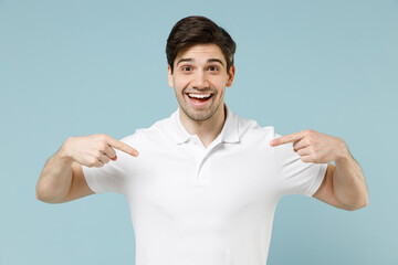Young fun surprised happy impressed unshaven cheerful man 20s in white casual basic t-shirt point...