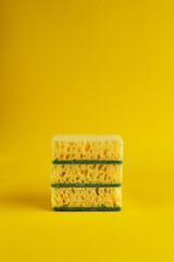 Minimal background with yellow sponges for washing dishes. Trendy yellow background