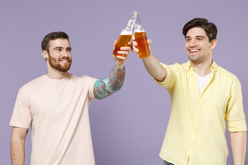 Two happy smiling cheeerful excited young men friends together 20s wearing casual t-shirt tattoo...