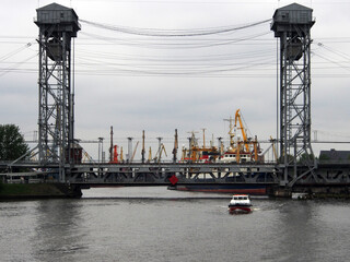 Drawbridge on the background of gantry cranes and ships in the sea, cargo port. Terminal of a sea or cargo port.