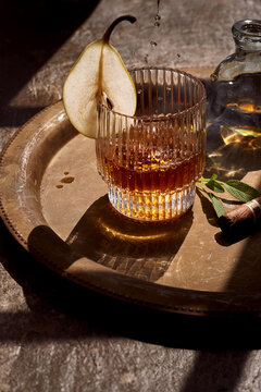Glass of whiskey with cigar placed on tray