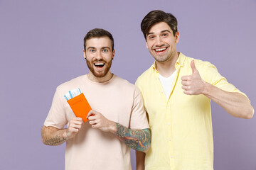Two traveler tourist men friends wear t-shirt hold passport ticket show thumb up tattoo translate...