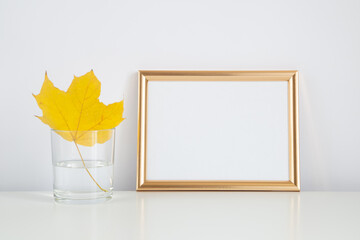 Autumn frame, background. Thanksgiving mockup with golden frame and yellow leaf. Halloween, fall minimal composition