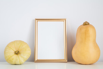 Autumn frame, background. Thanksgiving mockup with golden vertical frame and yellow pumpkins. Halloween, fall minimal composition