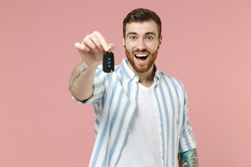 Young happy smiling satisfied caucasian unshaven man 20s wearing blue striped shirt giving car keys...