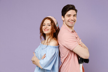 Two happy smiling traveler tourist woman man couple in summer casual clothes stand back to back isolated on purple background. Passenger travel abroad on weekends getaway. Air flight journey concept.