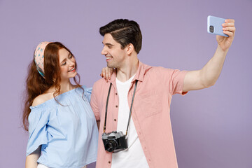 Two happy smiling traveler tourist woman man couple in shirt do selfie shot mobile phone photo social network isolated on purple background Passenger travel abroad weekend getaway Air flight concept.