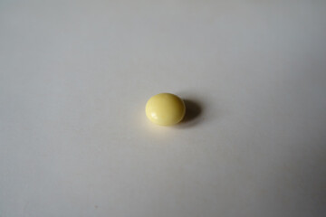 1 small round light yellow pill of xylitol