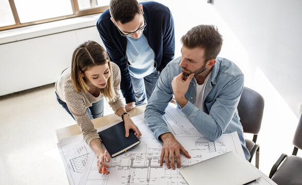 Group of architecture students examining blueprint .Educational concept.	
